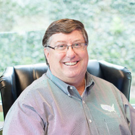 Smiling man wearing glasses in chair